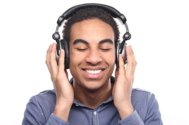 Siyah adam kulaklıkla müzik dinliyor.