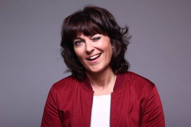 Yetişkin kadın beyaz arka plan üzerinde göz kırpıyor.