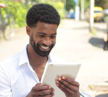 Siyah adam açık havada bir tablet Pc kullanma