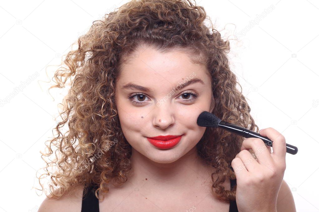 Beautiful caucasian woman is using face brush