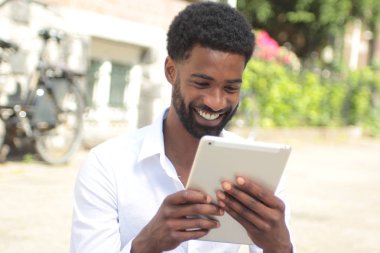 Siyah adam açık havada bir tablet Pc kullanma