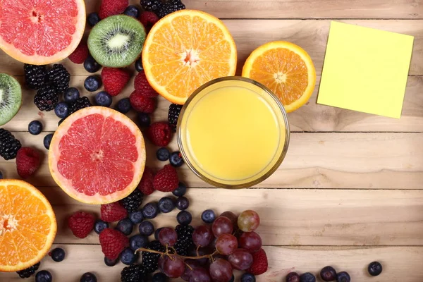 木製の背景にジュースと異なる果物やベリーのセット — ストック写真