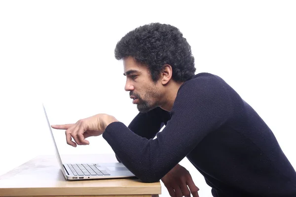 Black man using a laptop computer on table