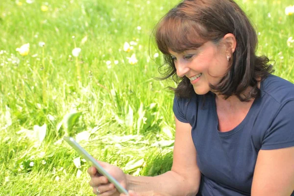 Woman using tablet pc in park