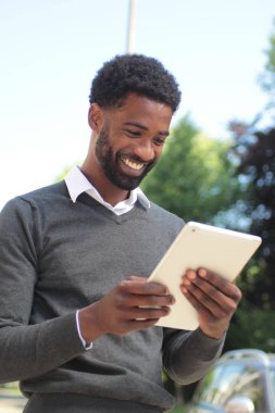 Siyah adam açık havada bir tablet Pc kullanma