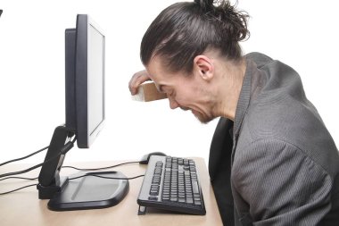 Beyaz adam masadaki bilgisayarda çalışıyor