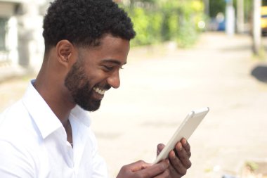 Siyah adam açık havada bir tablet Pc kullanma