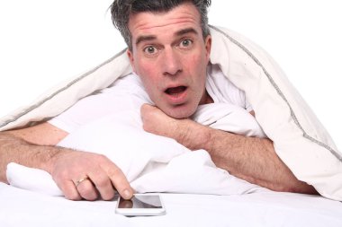 Yaşlı beyaz adam yatakta yatıyordu süre istimal hareket eden telefon