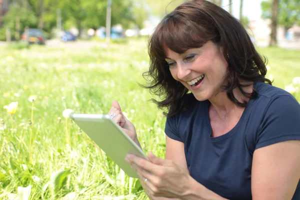 Woman using tablet pc in park