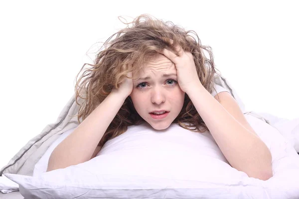 stock image Beautiful young girl is lying on bed and upset