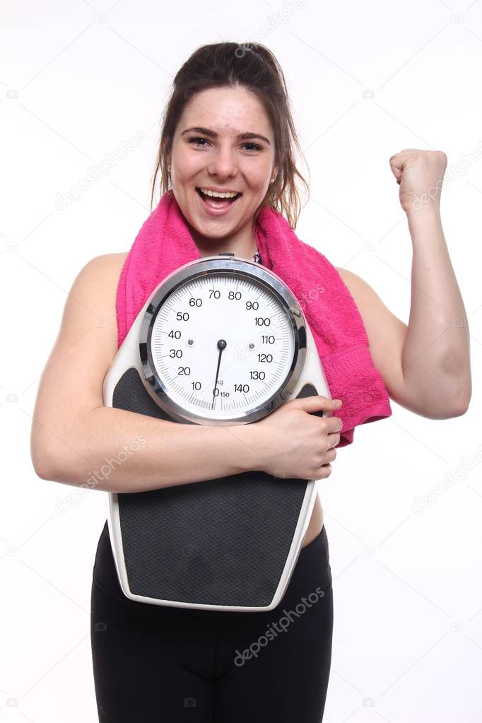 Young sportswoman is holding weight scale