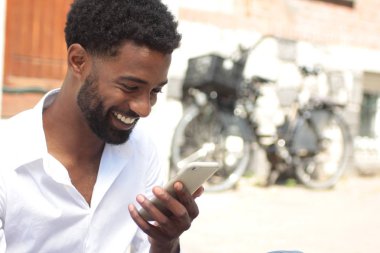 Cep telefonu açık havada kullanan siyah adam