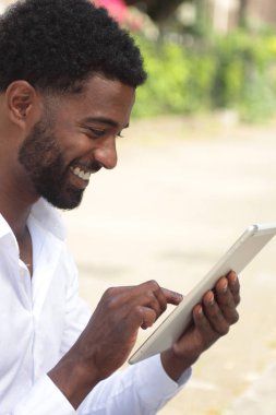 Siyah adam açık havada bir tablet Pc kullanma