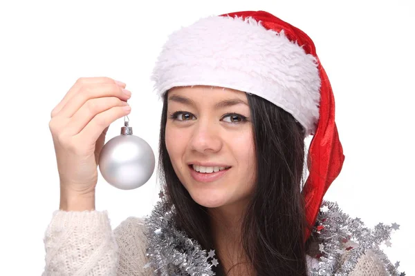 クリスマスの帽子と保持ボール幸せな若いアジアの女の子が着ています — ストック写真