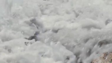 Dalgalar deniz kıyısındaki kayalıklarda kırılıyor.