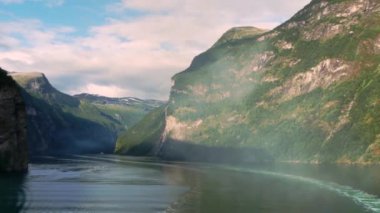 Şelaleli büyük yeşil dağlar Norveç fiyortlarını oluşturur.