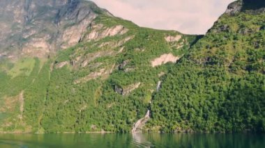 Şelaleli büyük yeşil dağlar Norveç fiyortlarını oluşturur.