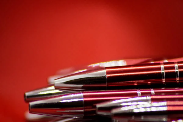 Ballpoint pens. Metal pens collection. Ball pens isolated on red background