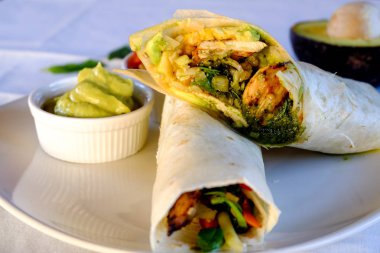 Burrito tamamladı tavuk, sebze ve beyaz arka plan üzerinde avokado sosu ile. Tavuk dürüm, Meksika yemeği.