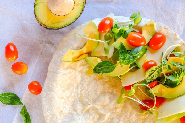 Vejetaryen burrito çizgili çerçeve, domates, yemek pişirmek için malzemeler avokado peynir. üstten görünüm kapat