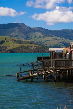 Yeni Zelanda'da bir gölde, Yeni Zelanda, şaşırtıcı, kalbinde dağlarla çevrili akaroa okyanusa Fishermans ev evler