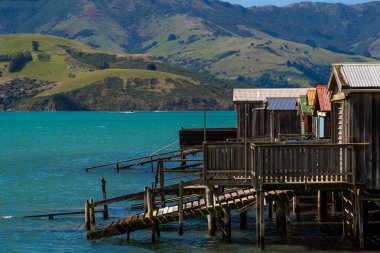 Yeni Zelanda'da bir gölde, Yeni Zelanda, şaşırtıcı, kalbinde dağlarla çevrili akaroa okyanusa Fishermans ev evler