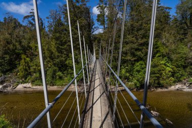 Pororari Nehri 'ndeki uzun köprü, Pororari Nehri Pisti' ndeki manzara, Yeni Zelanda, Güney Adası, Vahşi Yeni Zelanda Ormanı, Catlins, Güney Adası. 