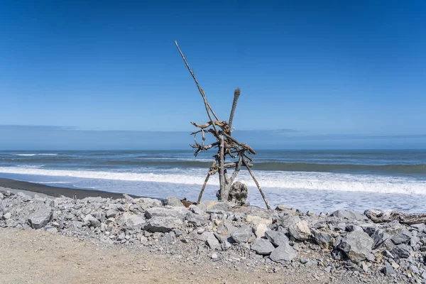 Hotikita Yeni Zelanda sahilindeki ölü odun, Yeni Zelanda 'daki inanılmaz plaj, sahili ve dalgaları olan inanılmaz okyanus görüntüsü, Yeni Zelanda sahillerindeki eski ahşap.
