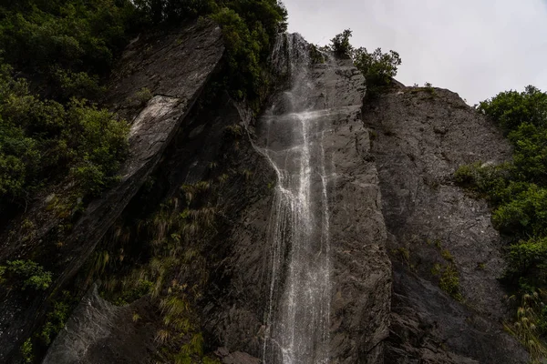 waterfalls at franz Joseph glacier in New Zealand, waterfall next to a glacier, Franz Josef glacier waterfalls landscape, New Zealand