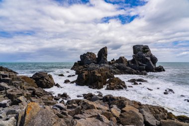 Cape Foulwind 'deki inanılmaz sahil şeridi. Yeni Zelanda Yeni Zelanda. Arka planda okyanus dalgaları, Yeni Zelanda' da büyük kayalar ve plajlar.
