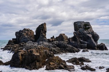 Cape Foulwind 'deki inanılmaz sahil şeridi. Yeni Zelanda Yeni Zelanda. Arka planda okyanus dalgaları, Yeni Zelanda' da büyük kayalar ve plajlar.