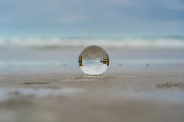 crystal ball on tunnel beach in New Zealand with rocks in the background, lansball on the beach, amazing tunnel beach in New Zealand with a crystal ball in the foreground,