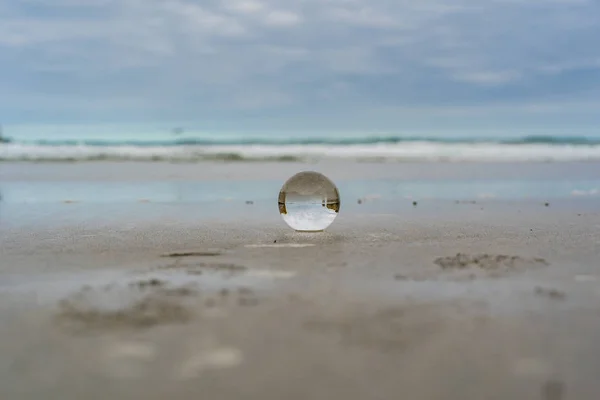 以岩石为背景的新西兰隧道海滩上的水晶球 以水晶球为前景的新西兰隧道海滩上的兰斯球 — 图库照片