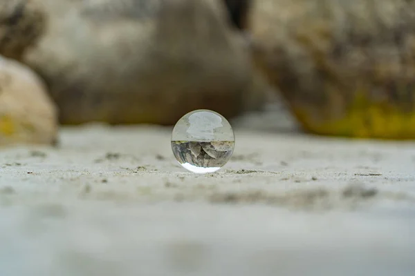 以岩石为背景的新西兰隧道海滩上的水晶球 以水晶球为前景的新西兰隧道海滩上的兰斯球 — 图库照片