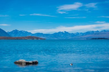 Yeni Zelanda 'daki Tekapo Gölü' ne, Yeni Zelanda 'daki Görkemli Dağ Gölü' ne Tekapo Gölü 'ne, arka plandaki dağlarla muhteşem bir göle geniş bir bakış.