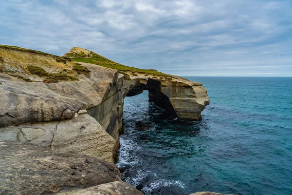 photography of tunnel beach in New Zealand, DUNEDIN, NEW ZEALAND Tunnel beach, Dunedin, South island of New Zealand, amazing coast line from above with a drone, Cliff formations at Tunnel Beach