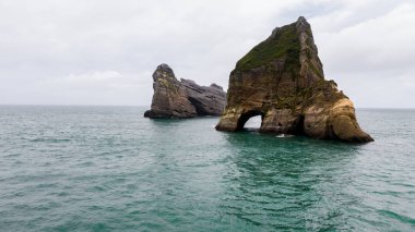 Whariki Sahili 'nde dalgalı kum ve kaya oluşumları yukarıdan, Nelson, Kuzey Adası, Yeni Zelanda, Archway Adaları okyanusta, Doğal duvar kağıdı arka planı, havadan inanılmaz kaya oluşumu