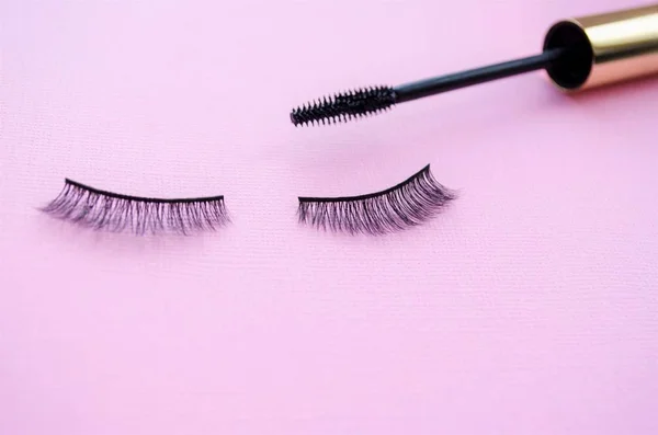 false eyelashes and mascara on a purple background