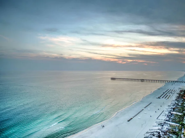 Arka planda bir iskele ile Meksika Körfezi üzerinden günbatımı