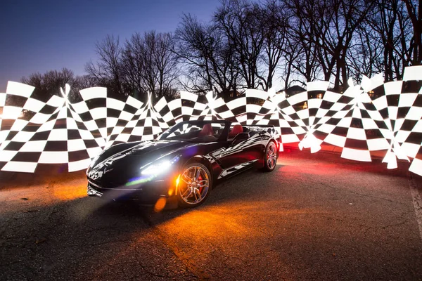 Siyah C7 corvette etrafında Damalı deseni ile gece ekranda. Omaha, Nebraska 19th Aralık 2017