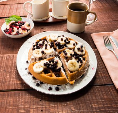 Waffel muz, yaban mersini ve kahve bir tablo ile