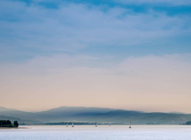 Bir dağ Gölü ile haze dağların üzerinden yelken