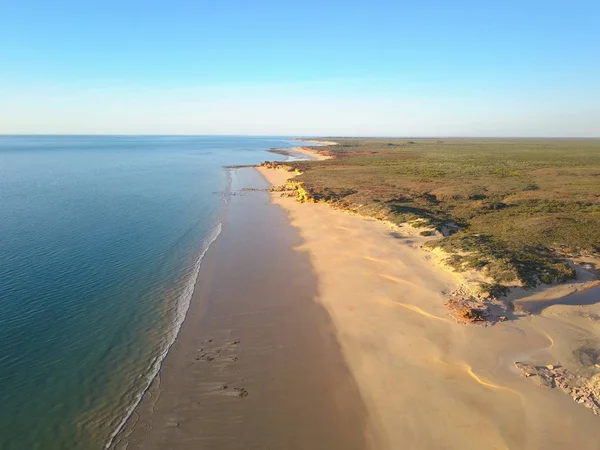 Okyanus plajı, kayalıklar, taşra manzarası, güneşli mavi gökyüzü ve ufuk kopyalama alanı ile Broome, Batı Avustralya yakınlarındaki uzak sahilin doğal panoramik manzarası.