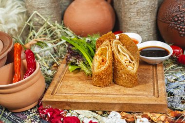 Sebzeli peynir ruloları, derin yağda kızartılmış, otlar ve soslu