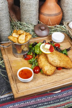 Balık meyilli tığ işi, patates rustik, yeşillik, kiraz domates, salatalık, domates ve krema sosları ile