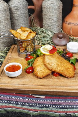 Balık meyilli tığ işi, patates rustik, yeşillik, kiraz domates, salatalık, domates ve krema sosları ile