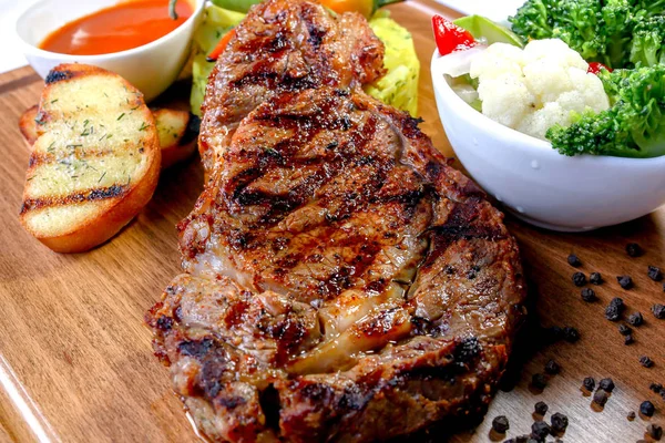 biberiye ve baharatlar ile rustik kesme tahtası üzerinde ızgara biftek