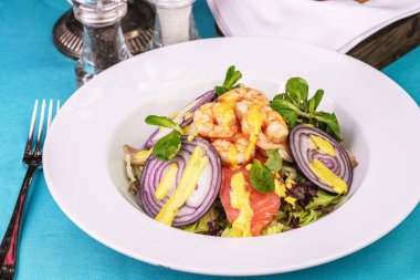 Akdeniz salatası. ızgara karides, kırmızı soğan halkaları, limon kabuğu, zencefil kökü ve zeytinyağı ile giyinmiş sebze