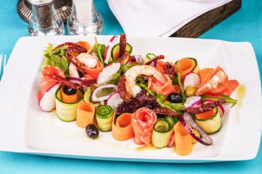 Akdeniz çerezi. Dilimlenmiş turp, domates, kızarmış karides, somon, soğan halkaları, biber ve yeşillik