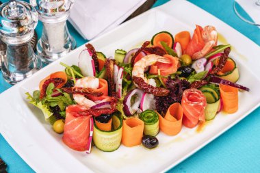 Akdeniz çerezi. Dilimlenmiş turp, domates, kızarmış karides, somon, soğan halkaları, biber ve yeşillik